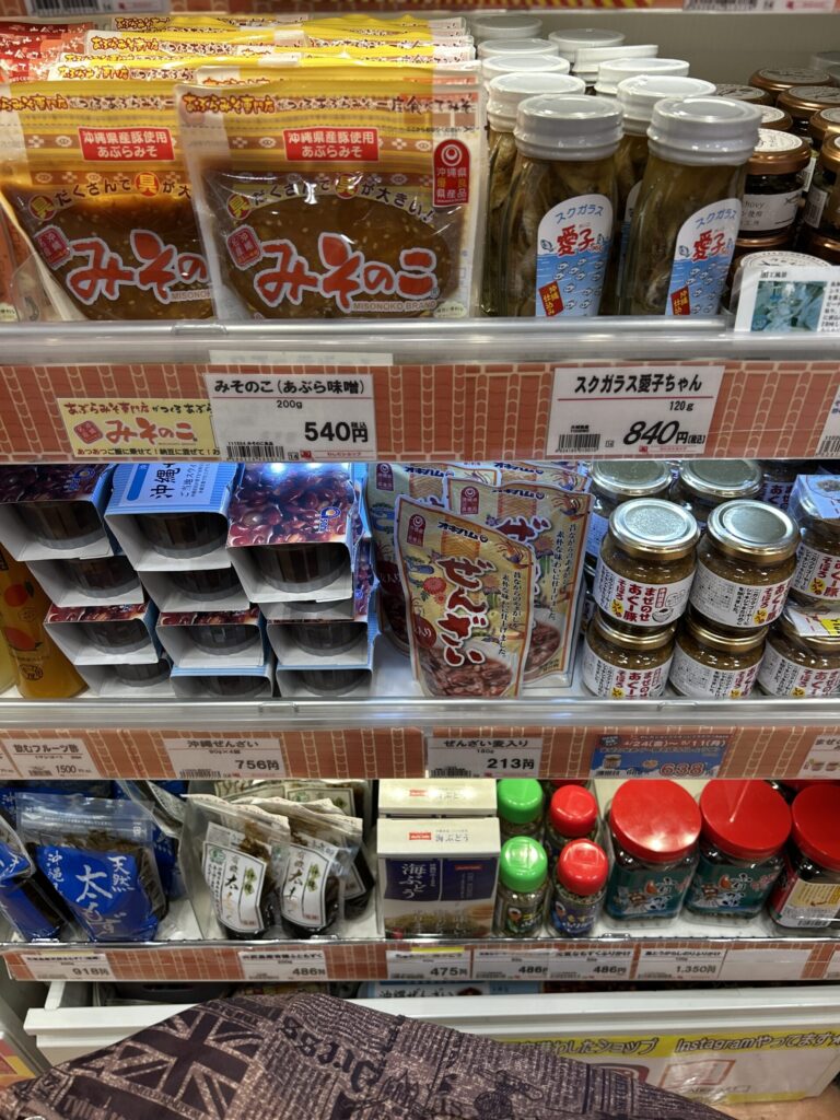 那覇空港の売店に並ぶ、オキハムの「沖縄ぜんざい」レトルトパウチ。赤いパッケージが目を引く。