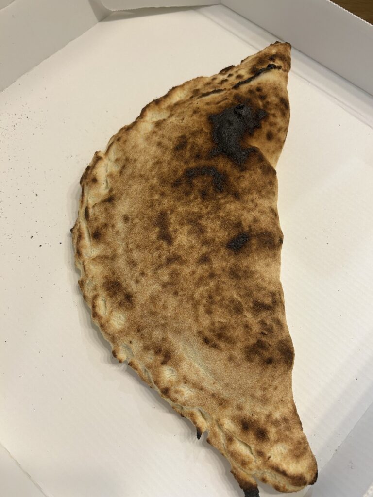 石窯ピザ酒場まるきからテイクアウトした、焼き立てのカルツォーネ。